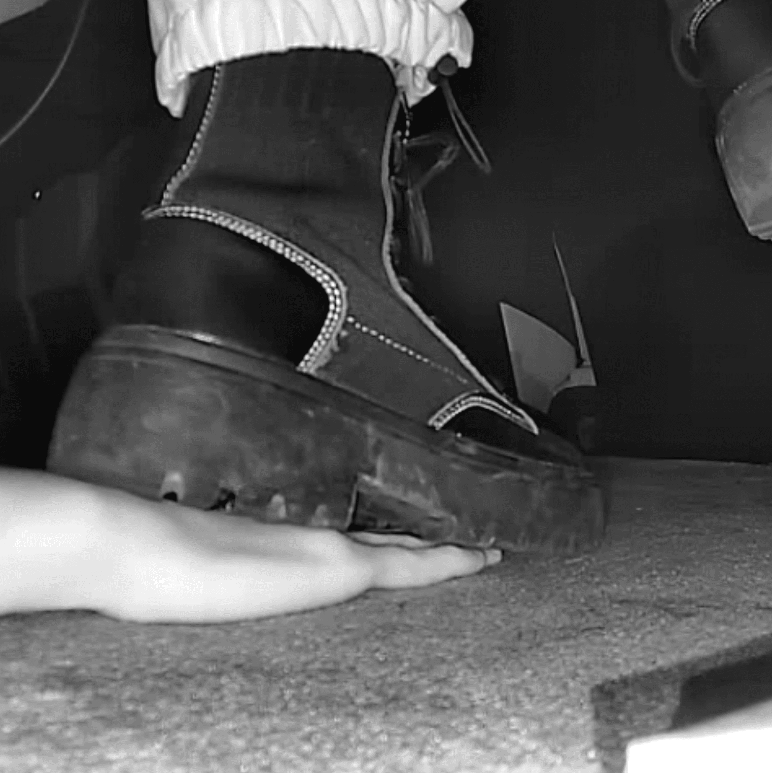 Girl candid steps on hand with chunky-heeled black ankle boots in the cinema