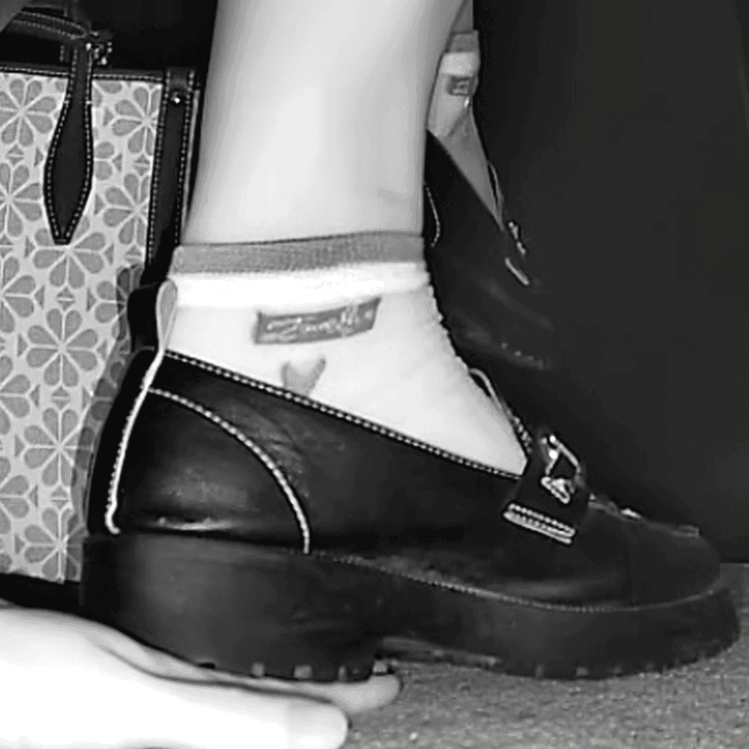 Cinema girl candid stepping on hand with leather shoes