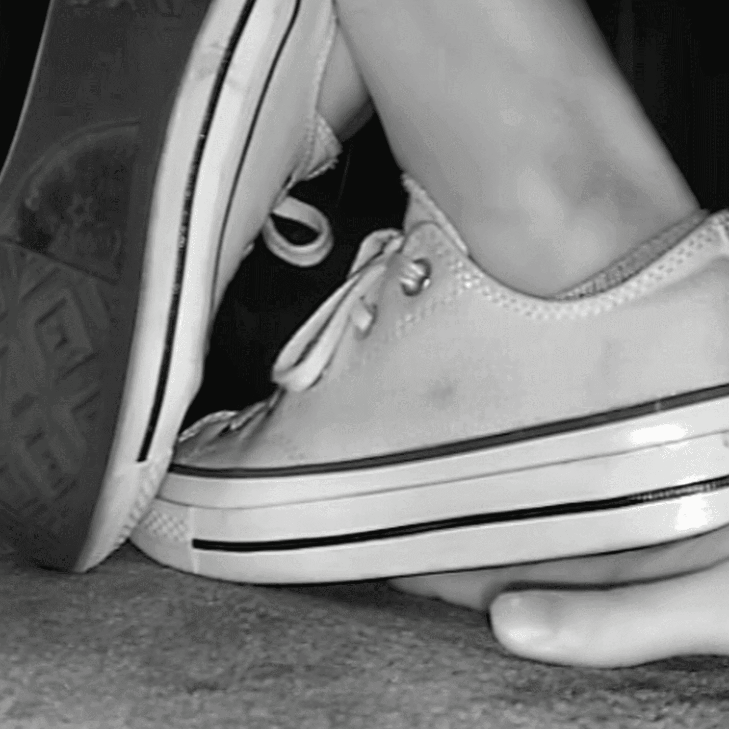 Girl in cinema wearing flat shoes + low-top Converse shoes candid trample hand