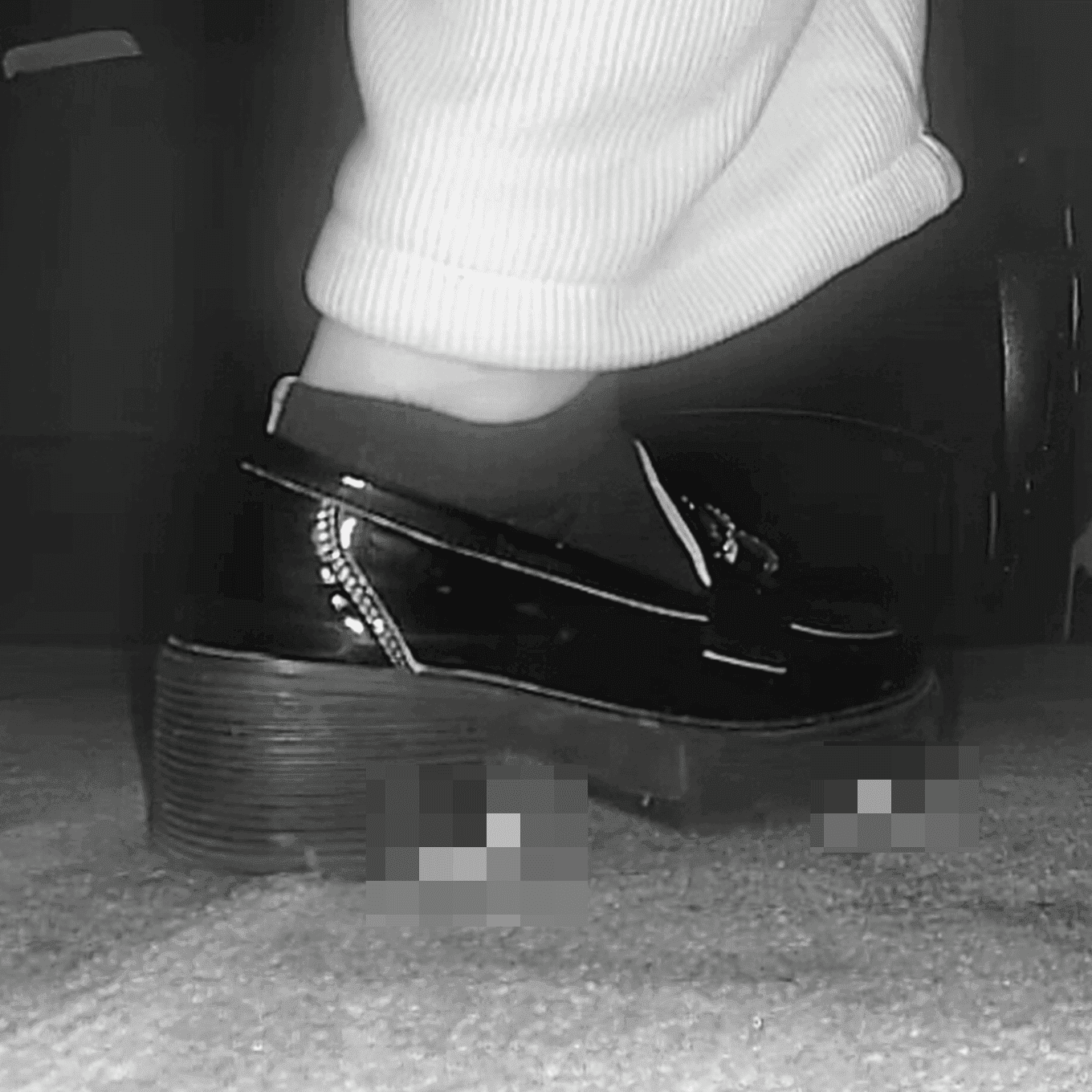 Woman candid crush with black leather shoes in cinema