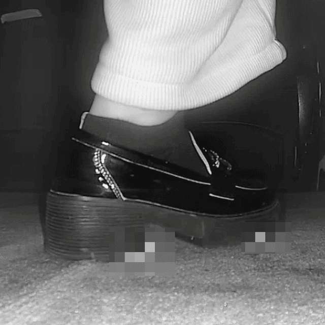 Woman candid crush with black leather shoes in cinema
