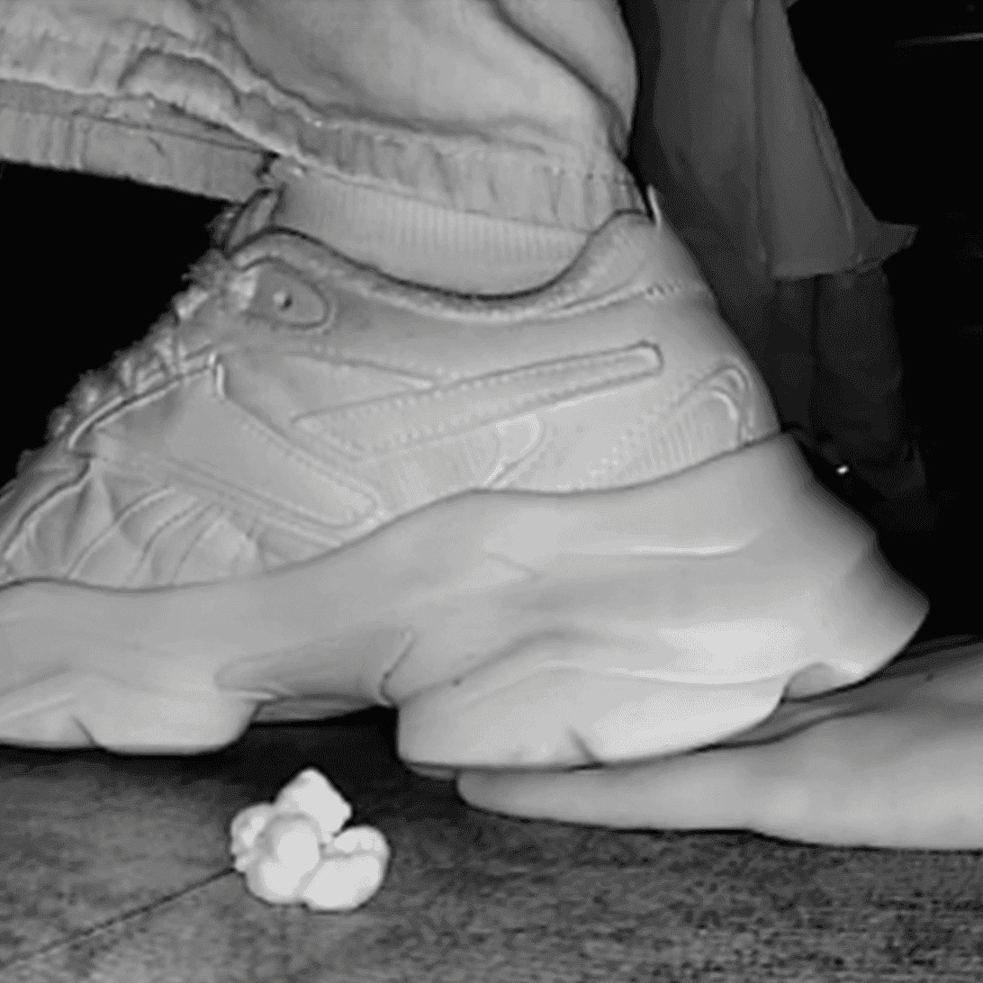 Woman candid crush with Reebok sneaker + sneaker candid hand trample in the cinema