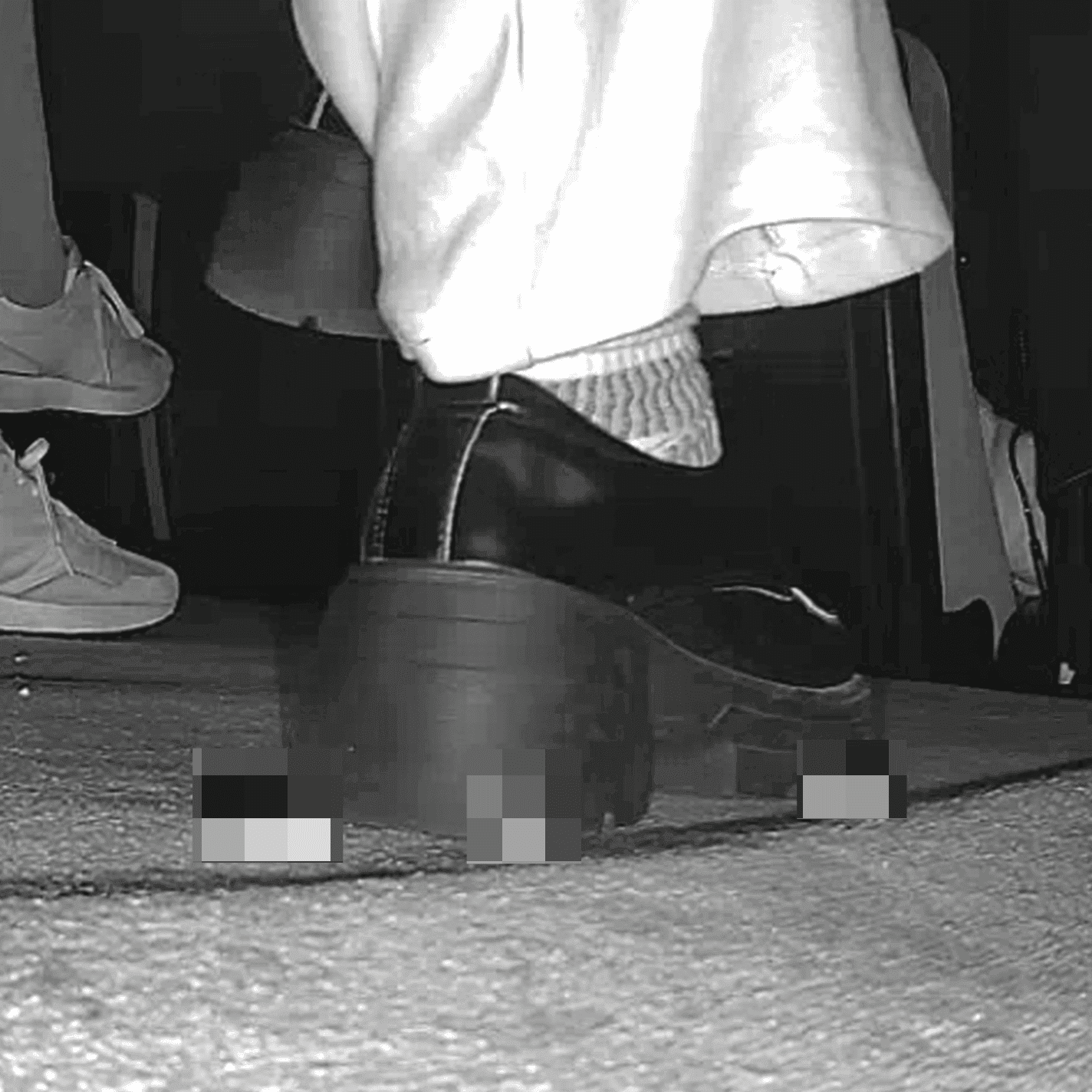 Woman candid crush with black chunky-heel leather shoes at cinema and stuck to the sole