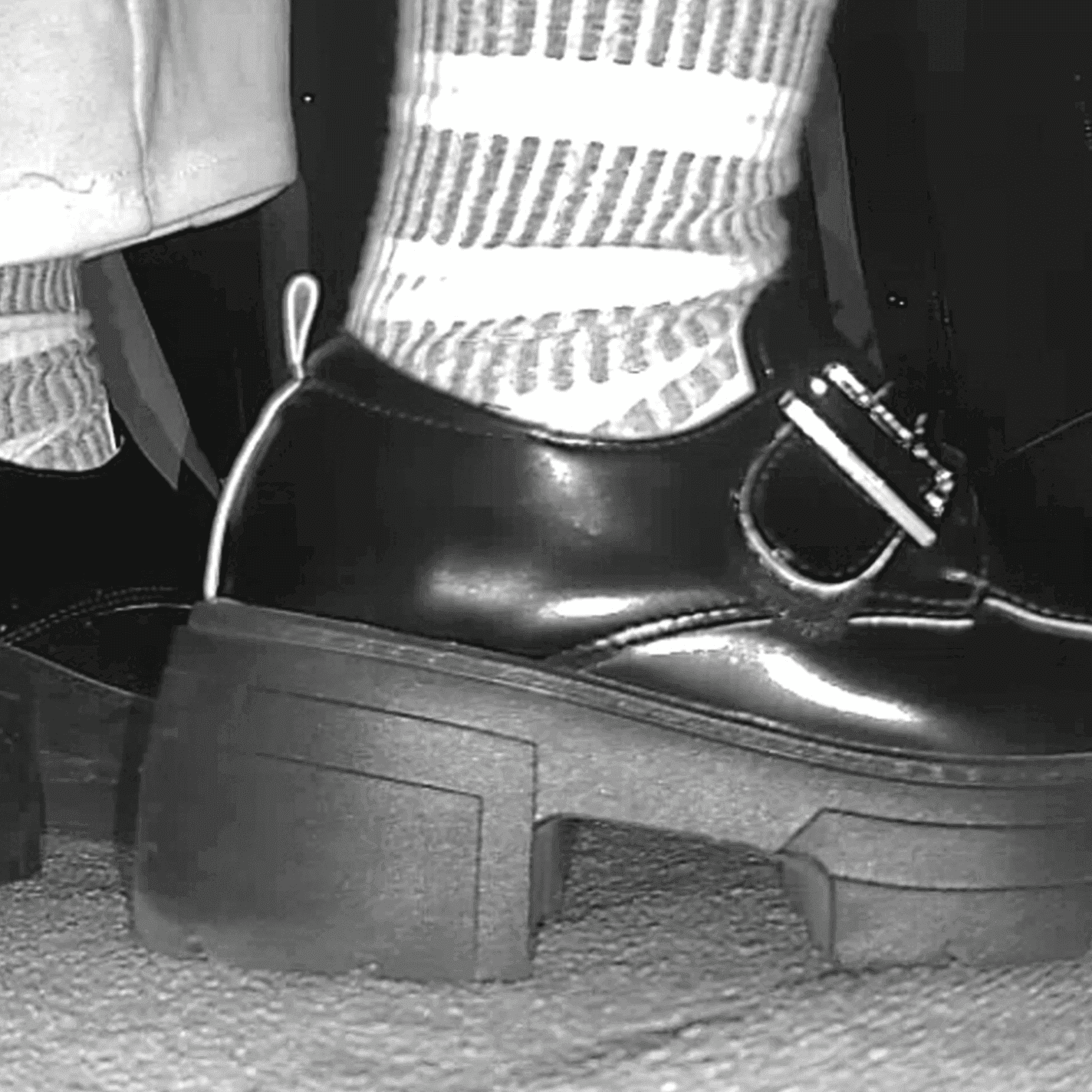 Woman candid crush with black chunky-heel leather shoes at cinema and stuck to the sole