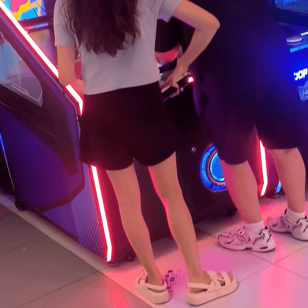 Game arcade lady in sandals and leather shoes candid crush and stuck to soles