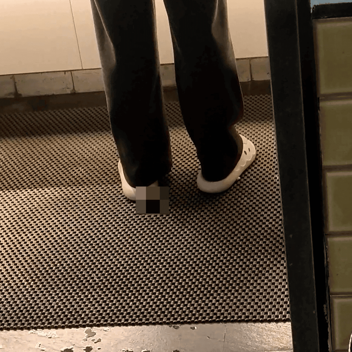 Woman in white socks and casual shoes candid crush repeatedly at the women's restroom entrance