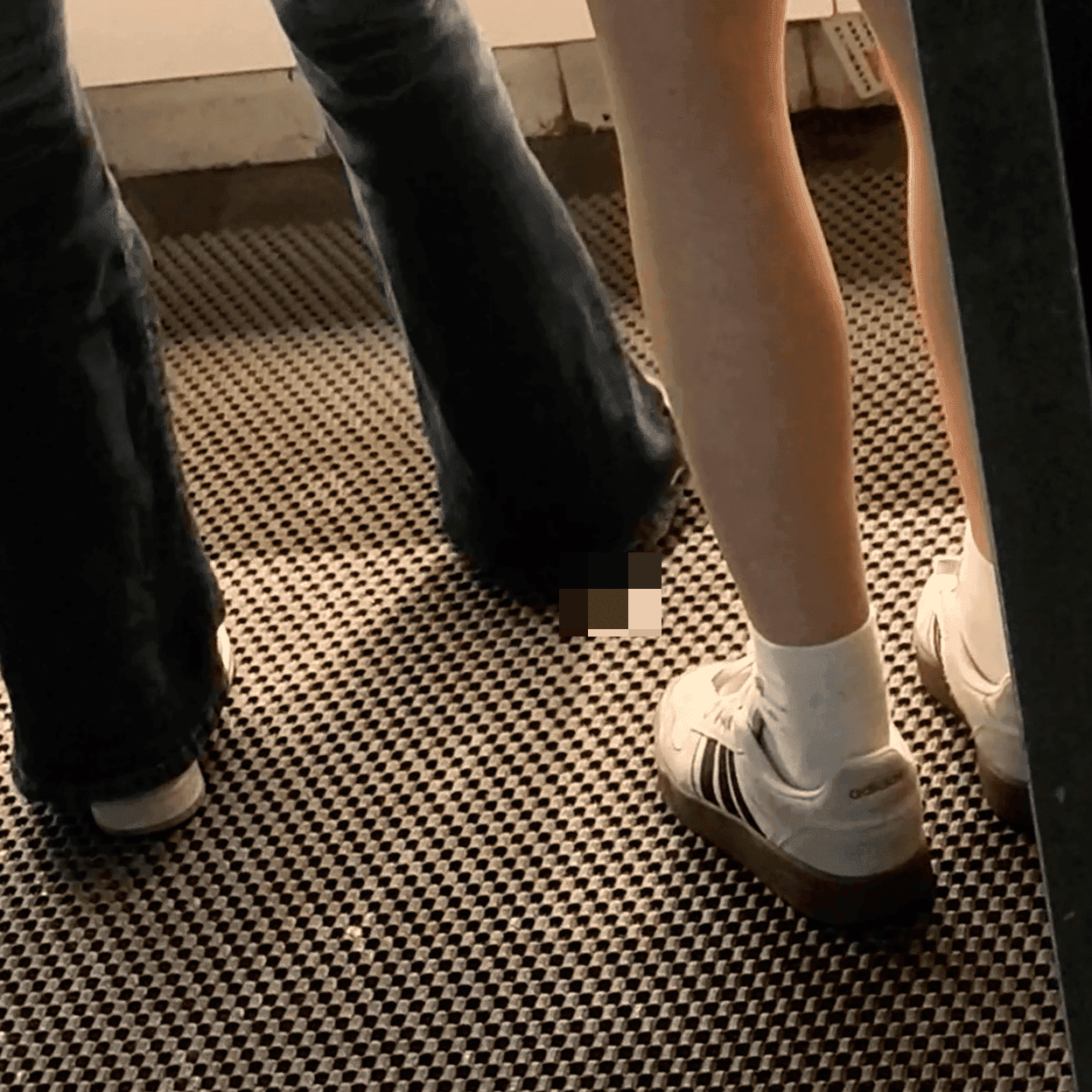 Woman in white socks and casual shoes candid crush repeatedly at the women's restroom entrance