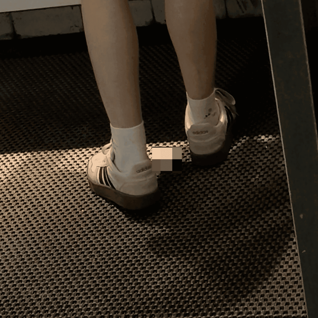 Woman in white socks and casual shoes candid crush repeatedly at the women's restroom entrance