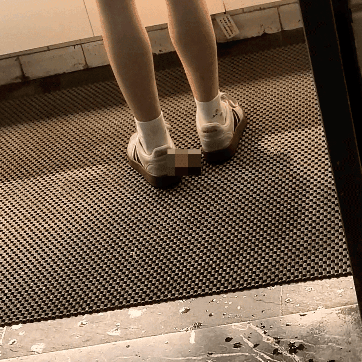 Woman in white socks and casual shoes candid crush repeatedly at the women's restroom entrance