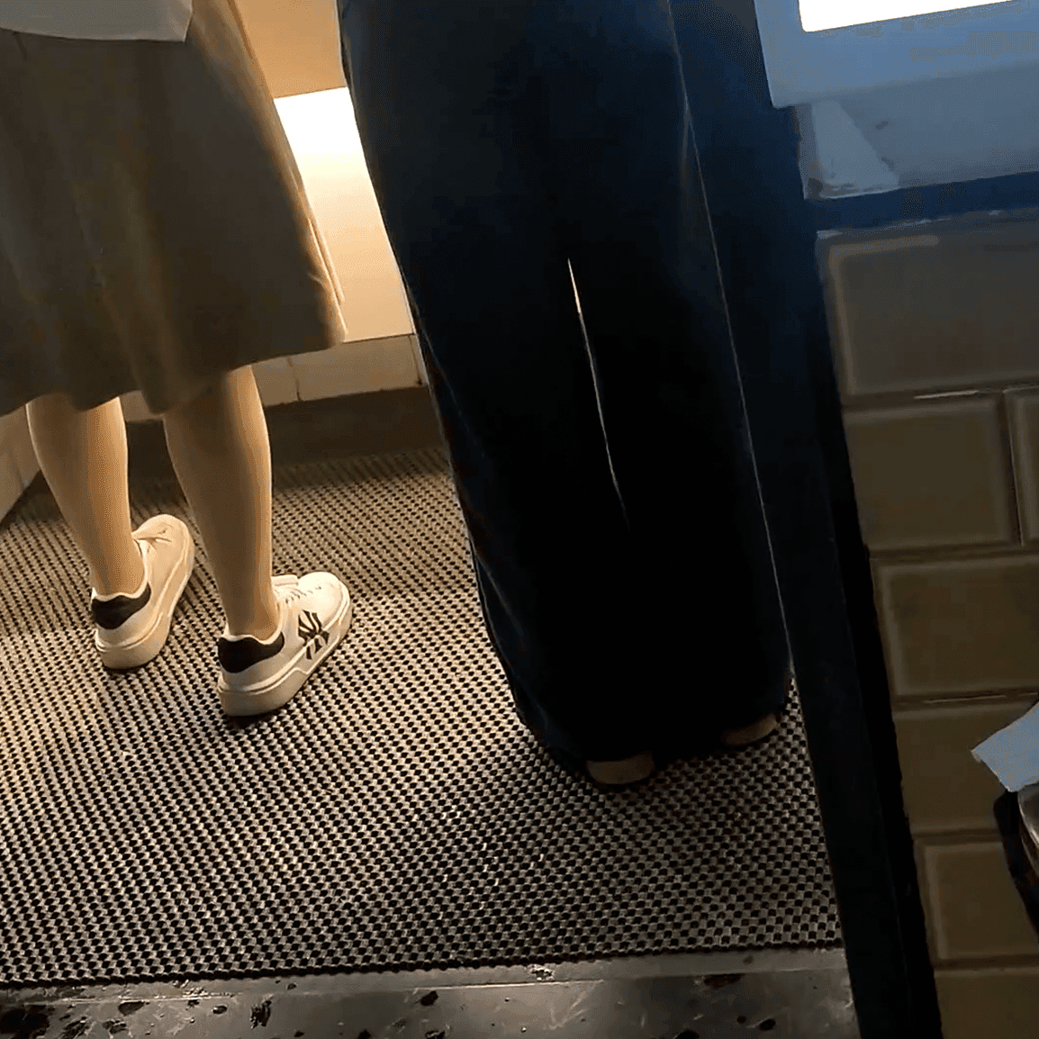 Multiple women in sneakers candid crush at the women's restroom entrance