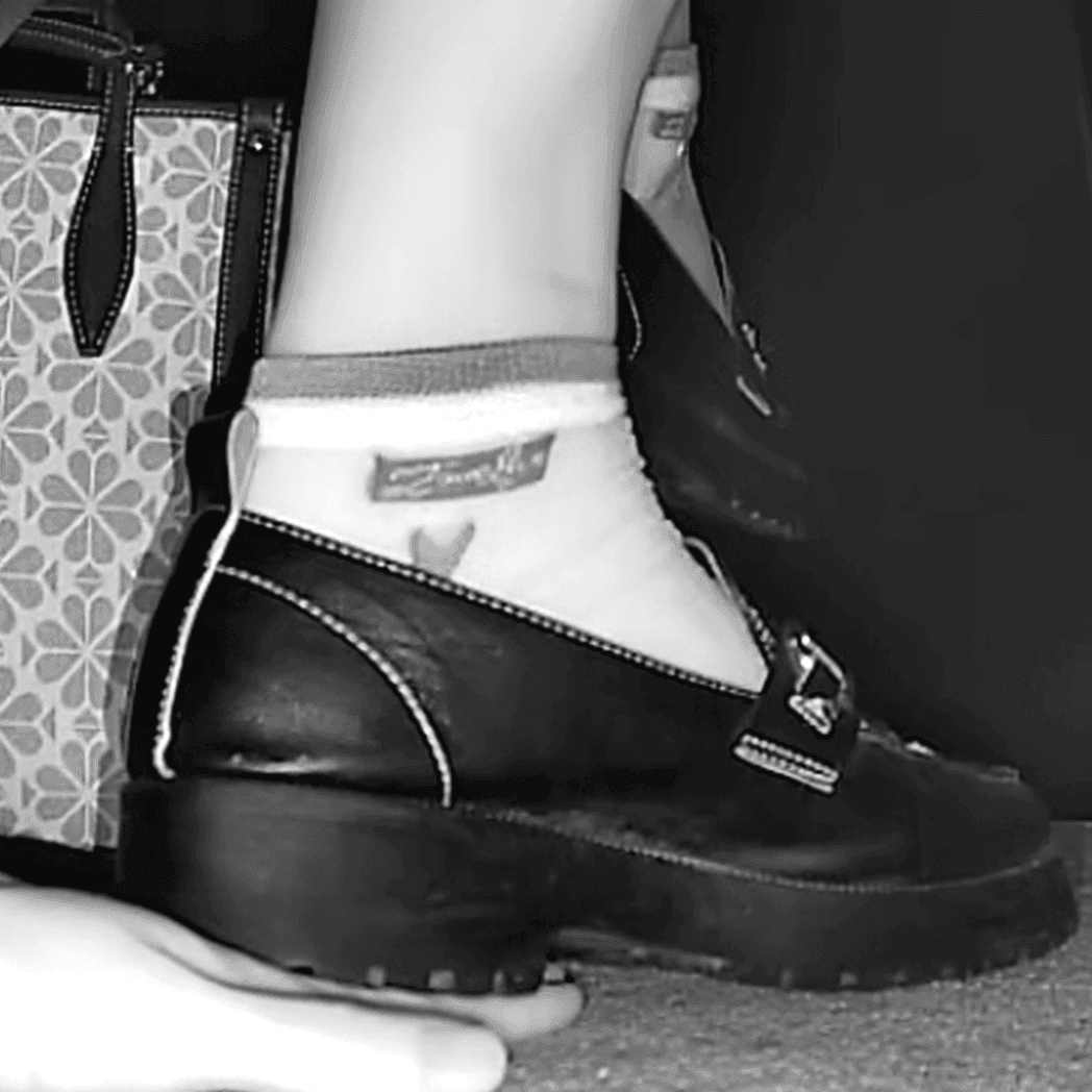 Cinema girl candid stepping on hand with leather shoes