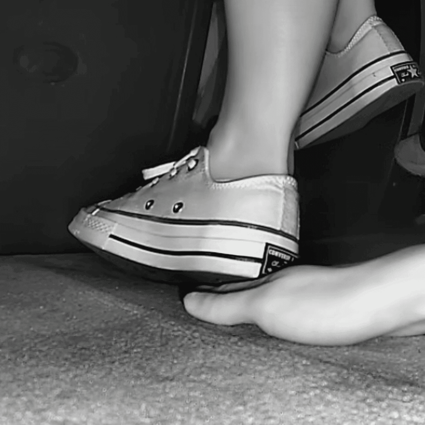 Girl in cinema wearing flat shoes + low-top Converse shoes candid trample hand