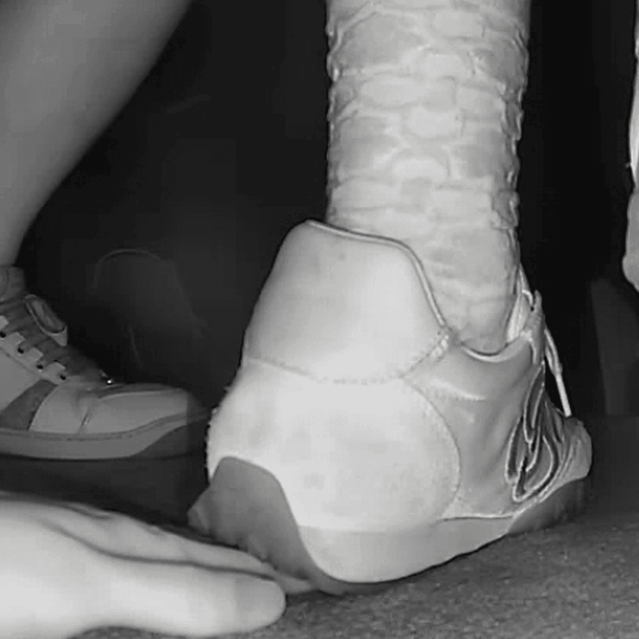 Girl in the cinema candid hand trample with sneakers and ankle boots