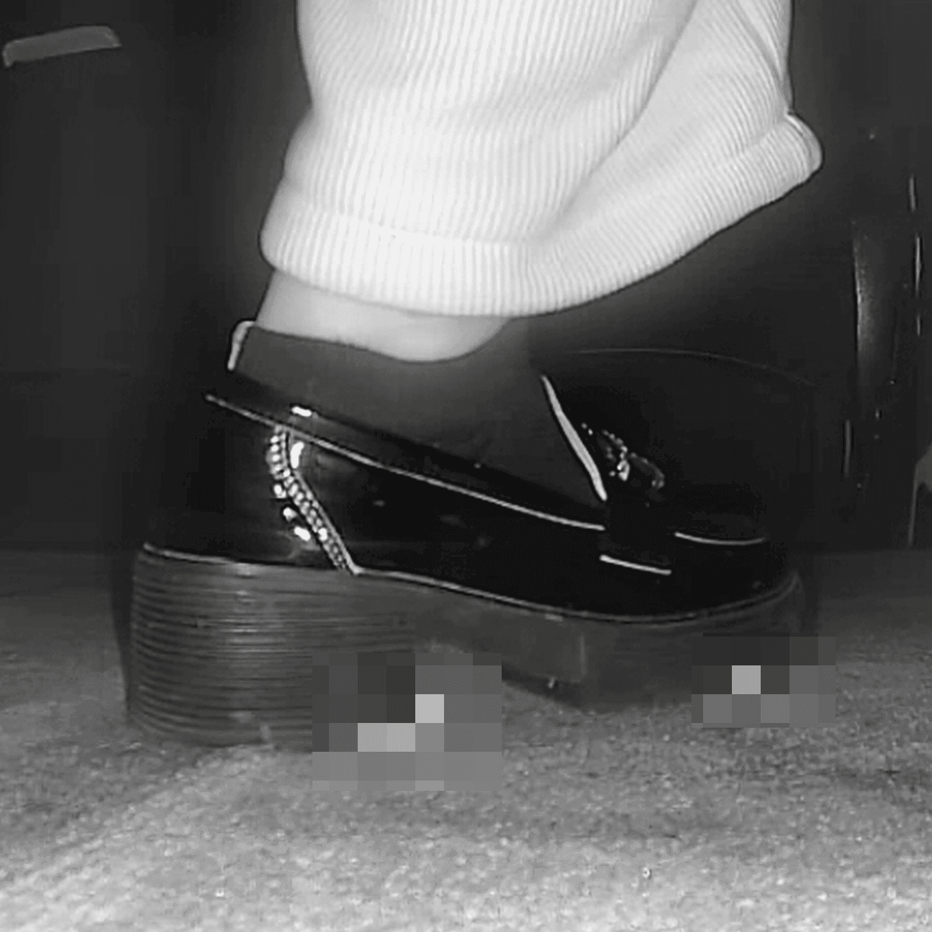 Woman candid crush with black leather shoes in cinema